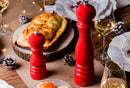 Moulin à Poivre Peugeot Paris u'Select en bois laqué rouge sur une table élégante avec plat et verre de vin.